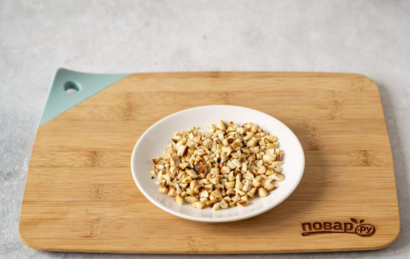 1. Этап. Баклажаны с арахисом: В сухой сковороде обжарьте арахис до золотистого цвета. Очистите его от шелухи и крупно порубите ножом.