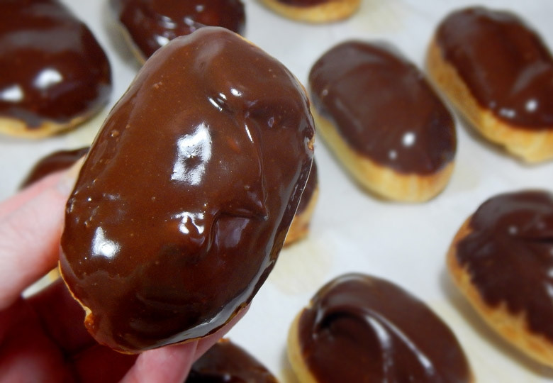 1. Этап. Пирожные Эклер: 16. Опустите пирожное одной стороной в шоколадный ганаш и выложите на стол для застывания.