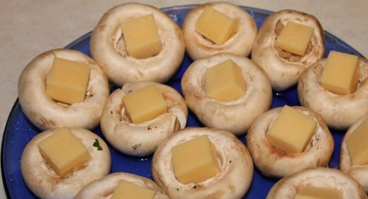 1. Этап. Шампиньоны, запеченные с сыром: Сыр нарезать кубиками и положить в шляпки грибов.