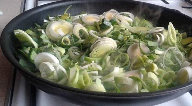 1. Этап. Лук тушеный: В сковороде разогрейте масло. Добавьте в неё лук. Обжарьте его пару минут.