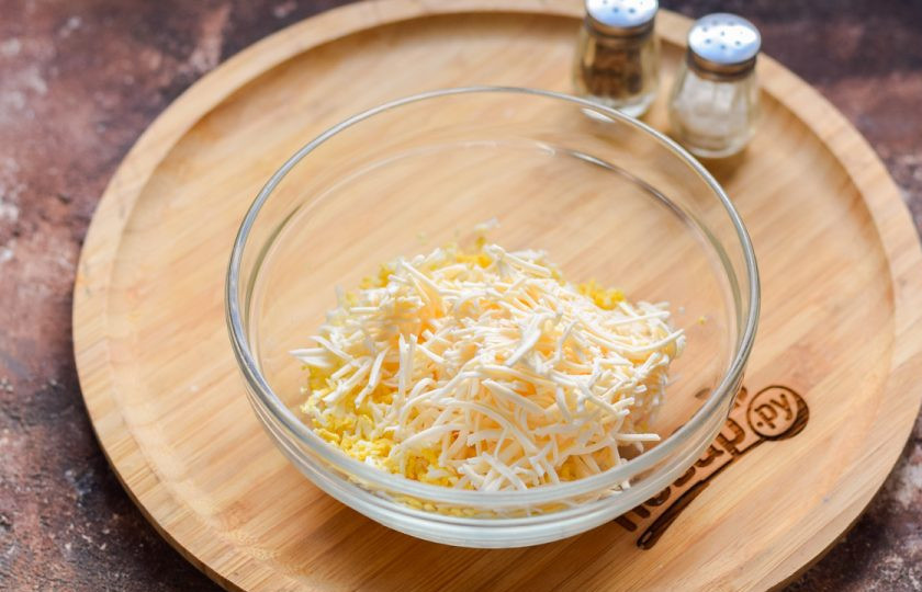 1. Этап. Бутерброды с плавленым сыром и икрой: Плавленый сыр натрите на мелкой терке, добавьте сыр к яйцу.