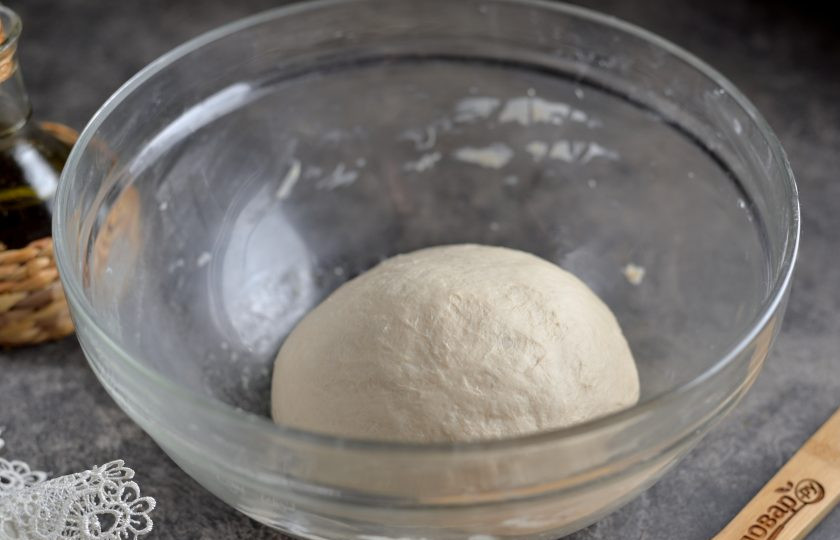 1. Этап. Пицца Каприччио: Из муки, теплой воды, масла, дрожжей, соли и сахара замесите тесто, оно будет чуть клеящимся к рукам. Накройте миску пищевой пленкой и поставьте ее в теплое место минут на 50-60. За это время тесто несколько раз поднимется, его нужно хорошо обмять руками.