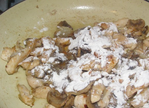 1. Этап. Фрикасе из курицы с шампиньонами: Теперь равномерно посыпаем мукой содержимое сковородки, перемешиваем и жарим минуты 2.