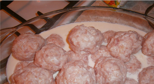 1. Этап. Тефтели со сливками в духовке: 1. Смешаем фарш, яйца и рис, получаем фарш. Солим, перчим и формируем тефтели. Выкладываем их в форму и заливаем сливками.