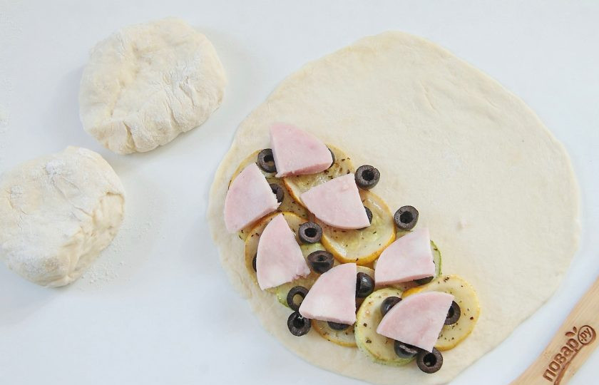 1. Этап. Кальцоне с цукини, оливками и моцареллой: Сверху посыпьте оливки и разложите ветчину.