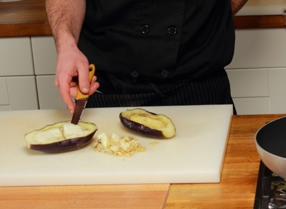 1. Этап. Баклажаны, фаршированные помидорами и сыром: Вырежьте мякоть из середины баклажанов, нарежьте ее кубиками.