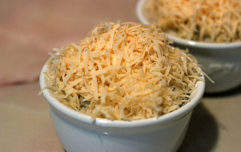 1. Этап. Жульен с грибами в духовке: Перекладываем жульен в формочки для запекания. Сверху присыпаем тертым сыром, отправляем в духовку. Температура должна быть 180 градусов. Запекаем, пока не расплавится 