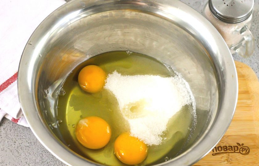 1. Этап. Сметанник из песочного теста: В глубокую емкость вбейте куриные яйца, всыпьте оставшийся сахарный песок, выложите сметану и все тщательно взбейте.