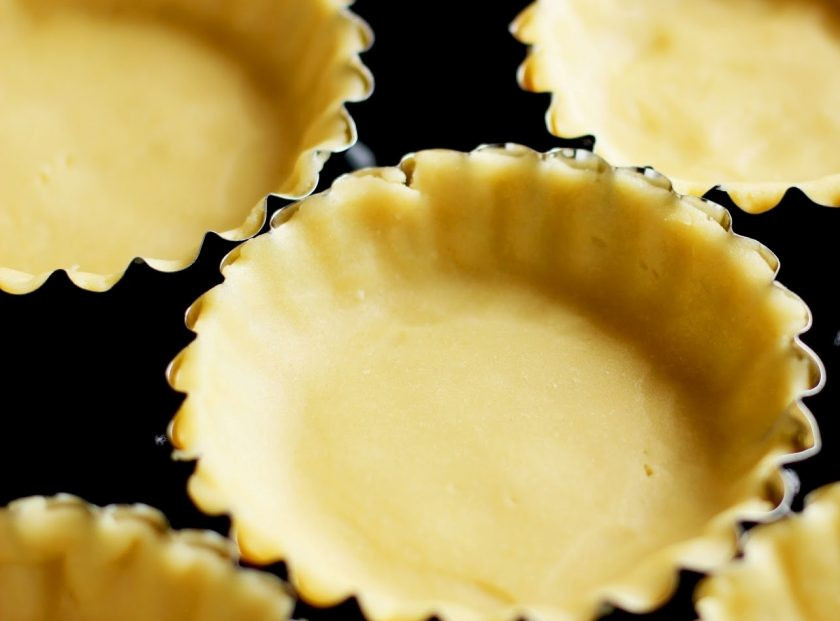 1. Этап. Корзинки с белковым кремом: 4. Тем временем подготовьте корзинки-формочки (кексницы), фольгу и фасоль или горох (для груза). Выложите тесто тонким слоем в формочки, равномерно распределив его по всей поверхности, а сверху выложите фольгу и на нее горох или фасоль.