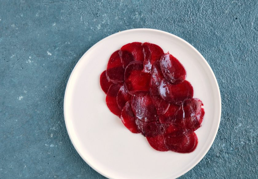 1. Этап. Карпаччо с рукколой: Выложите на тарелку свеклу, сверху рукколу и крем из тофу. Посыпьте жаренными семечками и мелко нарезанным луком.