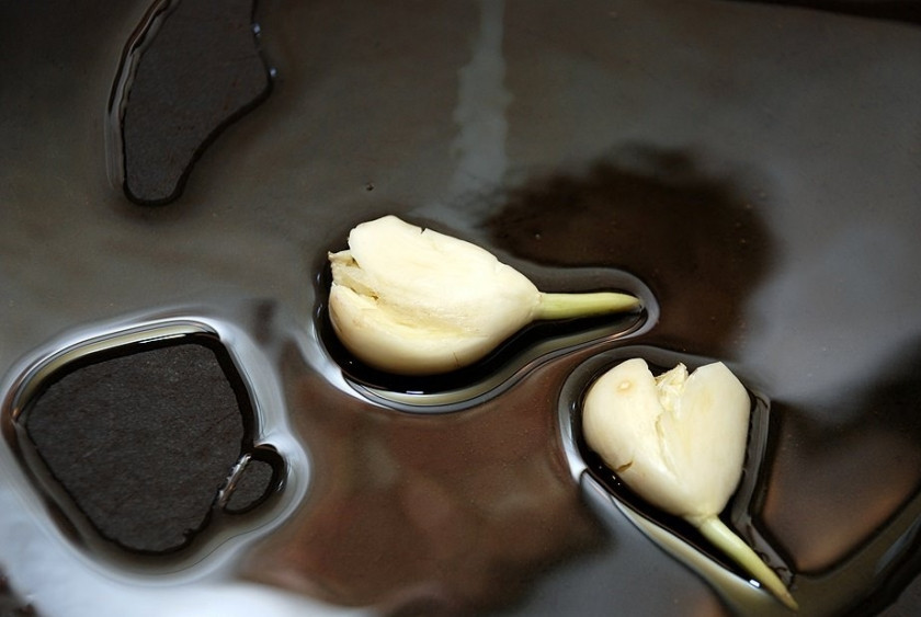 1. Этап. Ризотто с индейкой: В глубокой сковороде или сотейнике разогреваем оливковое масло. Выкладываем на сковороду два раздавленных зубчика чеснока, обжариваем до легкой румяности и выбрасываем чеснок.