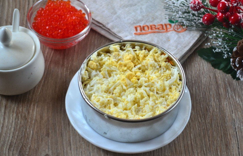 1. Этап. Сельдь под дорогой шубой: Выложите натертую на мелкой терке морковь, а сверху – яйца, также натертые на мелкой терке. По вкусу присолите.