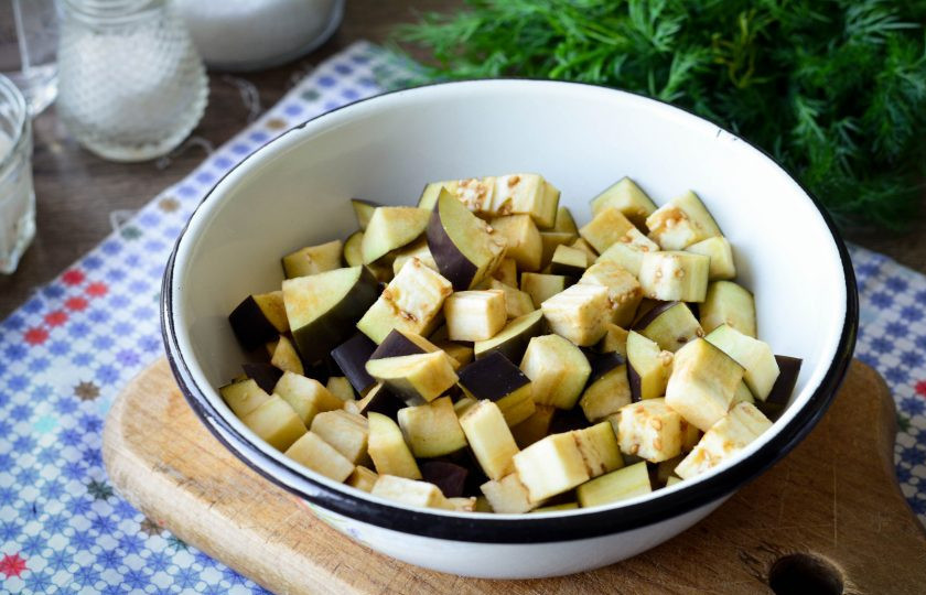 1. Этап. Теплый салат с баклажанами: Баклажаны промойте и нарежьте средними кубиками. Присыпьте солью и оставьте в таком виде на 15 минут на столе. Уйдет горечь из баклажанов.