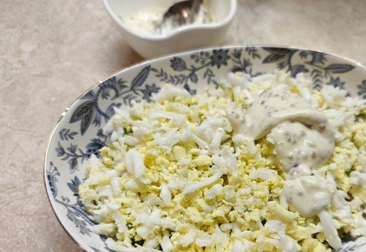 1. Этап. Салат Тиффани с авокадо: 3 слой - вареные яйца, натертые на терке. Смазать майонезной заправкой. Посыпать орехами.