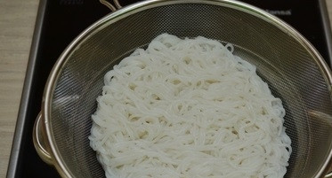 1. Этап. Курица с рисовой лапшой и соевым соусом: 1.Отварите рисовую лапшу по одному из способов, указанных на упаковке. Простейший способ: положите ее в кипящую воду и отваривайте не более 6 мин. После чего промойте через дуршлаг холодной кипяченой водой.