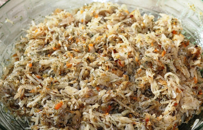 1. Этап. Вареники с квашеной капустой: Перекладываем обжаренный лук к капусте, добавляем укроп, петрушку, молотый перец и соль, перемешиваем все.