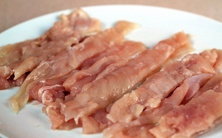 1. Этап. Куриные отбивные в сухарях: 2. Разрезаем отбитую грудку на тонкие полоски равной ширины. И оставляем на тарелке немного присыпав солью.