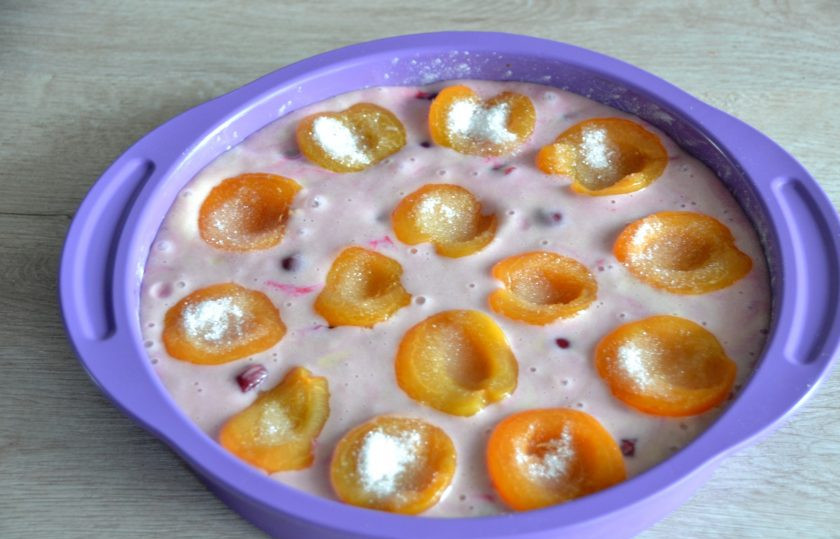 1. Этап. Шарлотка с абрикосами и вишней: Выложите тесто в форму, либо все сразу, вместе с вишней, либо слой теста, вишню, снова слой теста. Верх шарлотки украсьте перевернутыми половинками абрикосов, внутрь которых можно насыпать немного сахара.