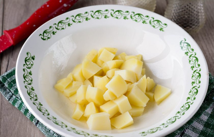 1. Этап. Салат с карбонатом: Сварите картофель и остудите. Нарежьте его кубиками.