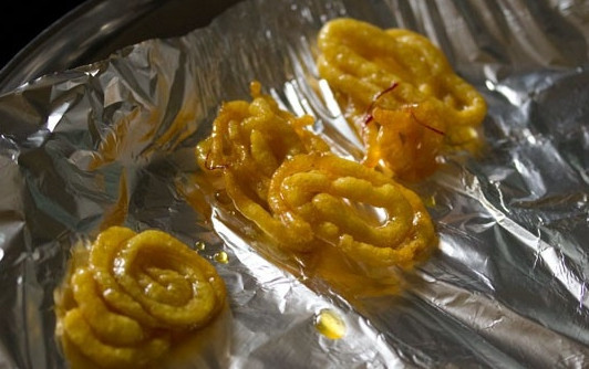 1. Этап. Джалеби индийские: 15. Окуните со всех сторон спиральки в сиропе и переложите на заранее приготовленный противень, застеленный фольгой. Вот и весь секрет, как сделать джалеби индийские. Интересно и ведь совсем несложно, да? Угощайтесь.