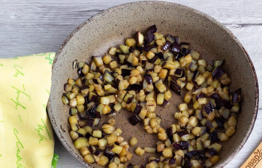 1. Этап. Чисанчи: В последнюю очередь обжарьте подготовленный баклажан. Жарьте 3-4 минуты, помешивая, затем добавьте сахар. Готовьте ещё 1-2 минуты.