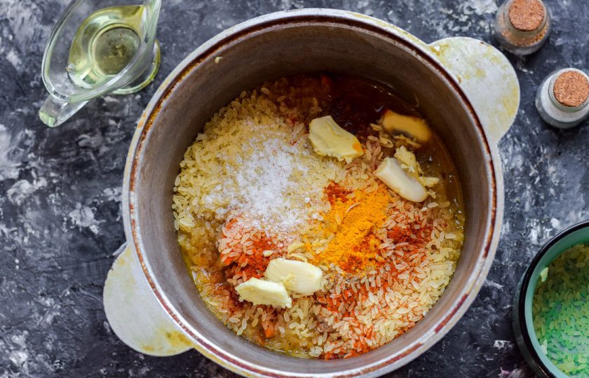 1. Этап. Плов с телятиной и карри: После переложите мясо в казан, добавьте рис, специи, карри, чеснок. Влейте два стакана горячей воды. Готовьте плов под крышкой 25 минут.