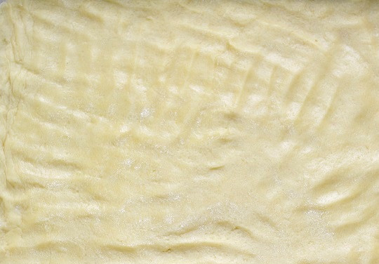 1. Этап. Торт Норд: Выложите тесто на противень, распределите его руками. Отправьте в разогретую до 180 градусов духовку на 15-20 минут.