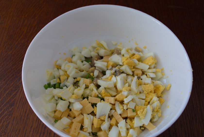 1. Этап. Салат с шампиньонами и сыром: Отварите куриные яйца в кипящей воде (6 минут). Очистите. Нарежьте кубиком. Добавьте к остальным продуктам салата.