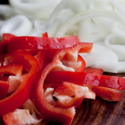 1. Этап. Курица по-венгерски: 1. Болгарский перец (желательно - красного цвета) промойте и нарежьте крупными полукольцами. Луковицу очистите и также нарежьте крупными полукольцами.