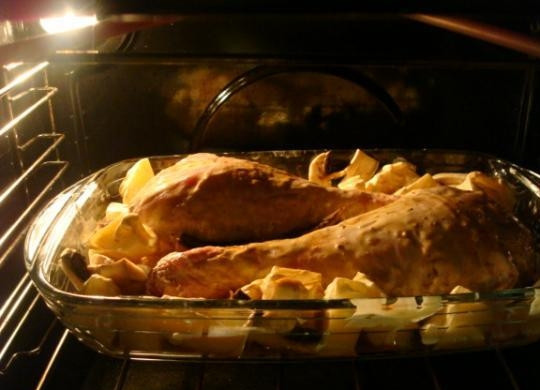 1. Этап. Индейка, запеченная со сметаной: Когда мясо замариновалось, можно включать духовку для разогрева и подготовить картофель: почистите, помойте и нарежьте его крупными ломтиками. Индейку достаньте из холодильника, переверните, чтобы опять сметанно-горчичный маринад распределился равномерно, выложите вокруг голеней нарезанный картофель и поставьте в разогретую духовку.