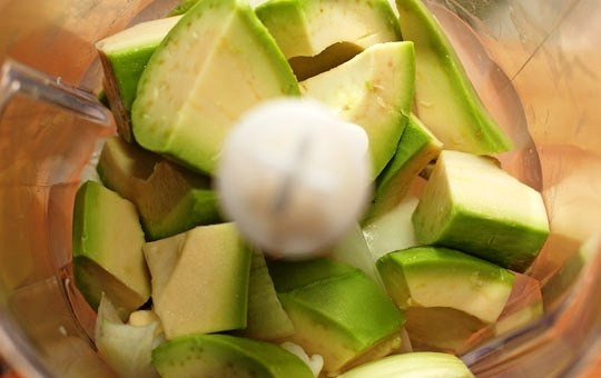 1. Этап. Печеный картофель с соусом из авокадо: Кладем в блендер кусочки авокадо и половину очищенной луковицы. Измельчаем до однородности.