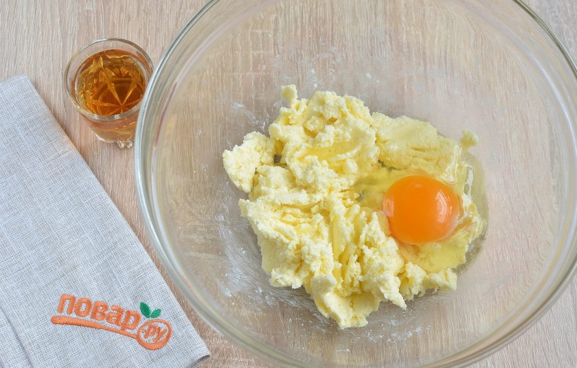 1. Этап. Берлинский яблочный пирог: 2. Масло соедините с сахаром, разотрите хорошо миксером или вилочкой. Добавьте яйцо, перемешайте. Влейте коньяк, снова перемешайте хорошо.