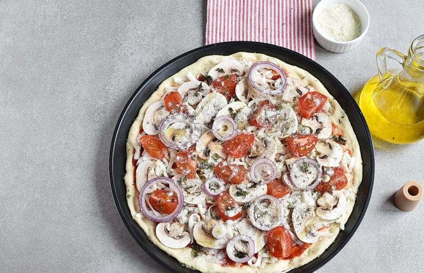 1. Этап. Пицца с шампиньонами: Завершающим штрихом посыпьте пиццу половиной тертого пармезана, посыпьте орегано и тимьяном, сбрызните чуток оливковым маслом.