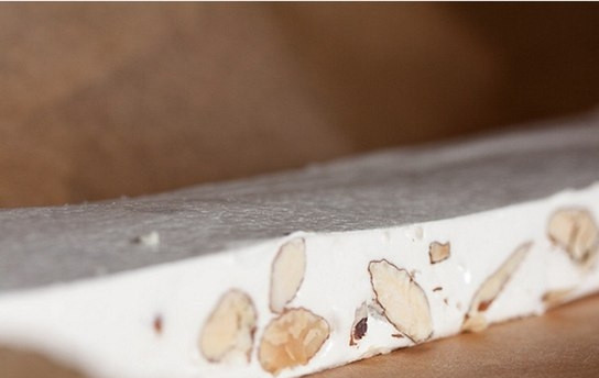 1. Этап. Нуга с миндалем: 5. Еще один лист смажьте маслом и выложите сверху. Все, можно оставить для застывания примерно на 10-14 часов. Когда нуга с миндалем в домашних условиях готова, аккуратно снимите пергамент и нарежьте небольшими порционными кусочками.