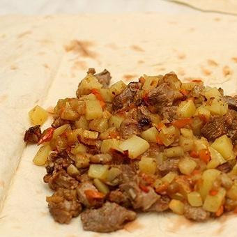 1. Этап. Мясо в армянском лаваше: Один из лавашей нарезаем на продольные ленточки - ими мы будем завязывать все остальные лаваши. Остальные лаваши разворачиваем, в центр кладем нашу начинку из двух сковородок.