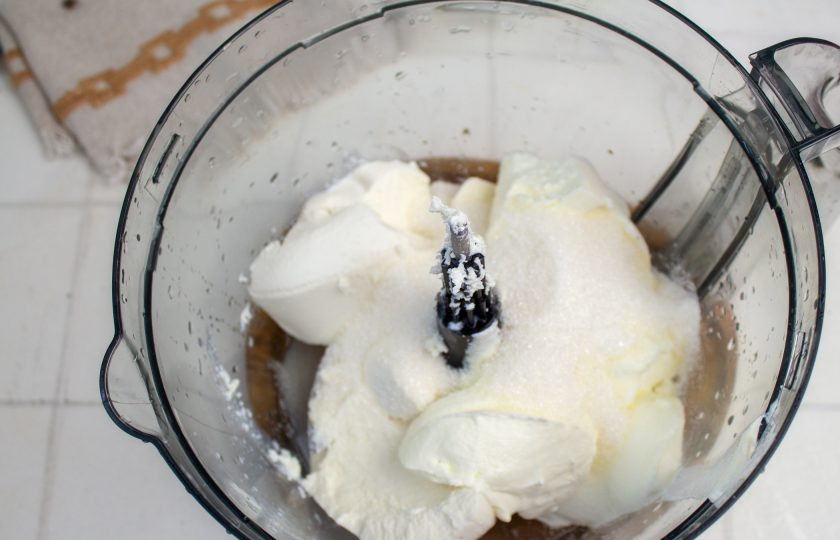 1. Этап. Лимонный чизкейк без выпечки: В чашу блендера выложите сливочный сыр, йогурт и сахар. Перемешайте до однородности.