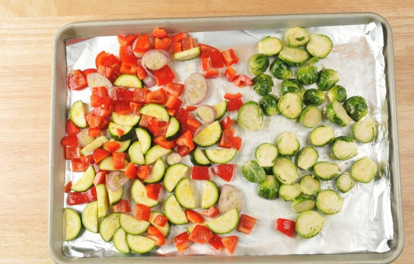 1. Этап. Багет с запечёнными овощами: 2. Затем перец, капусту, лук и цукини переложите на противень. Полейте овощи 2 ст. ложками масла, посыпьте половиной чеснока, солью и перцем.