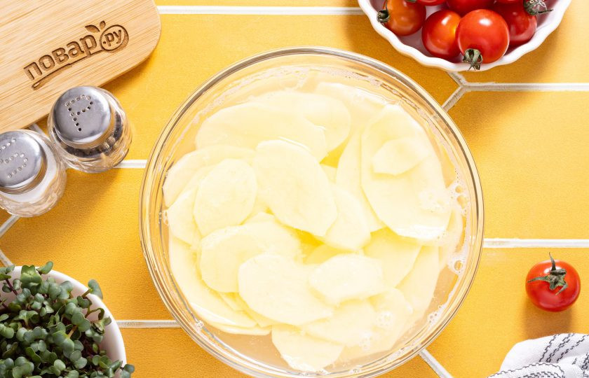 1. Этап. Чипсы из картошки в аэрогриле: Порезанный картофель замочите в холодной воде на 15 минут. Затем тщательно промойте картофель, чтобы вымыть лишний крахмал.