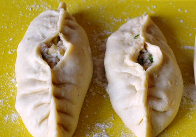 1. Этап. Расстегай с картошкой: Соберите тесто вокруг начинки, защипните края теста, оставив посередине отверстие. В него налейте чайную ложку куриного бульона. Смажьте расстегаи желтком и отправьте в разогретую до 200 градусов духовку на полчаса. Готовые пироги выложите на полотенце, дайте им немного остыть, затем подайте на стол.