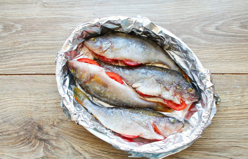 1. Этап. Окунь в духовке с чешуей: Форму для выпечки застелите фольгой и смажьте растительным маслом. Выложите в форму подготовленную рыбу.