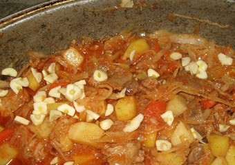 1. Этап. Рагу по-венгерски: Капусту уложим в казан, добавим чеснок и отправим казан в духовку. Тушить 40 минут при 180 градусах. Затем выключите печь и пусть рагу постоит еще 40 минут в духовке.