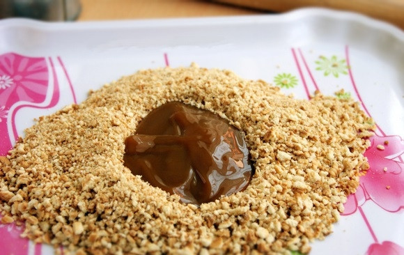 1. Этап. Конфеты с банановой начинкой: 2. Перекладываю измельченное печенье в широкую миску, в которой будет удобно мешать, и добавляю 1 столовую ложку с горкой сгущенного молока.