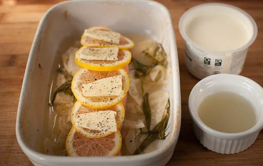 1. Этап. Семга в фольге в духовке: Теперь в форму уложите рыбку. На нее — кружочки лимона и кусочки масла, также в форму добавьте сметану и бульон.