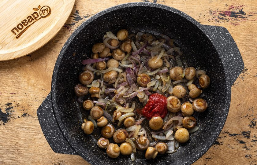 1. Этап. Грибы по-гречески: Влейте в сковороду воду, добавьте лимонный сок, томатную пасту, соль и чёрный молотый перец. Тушите грибы около 10 минут под крышкой на небольшом огне.