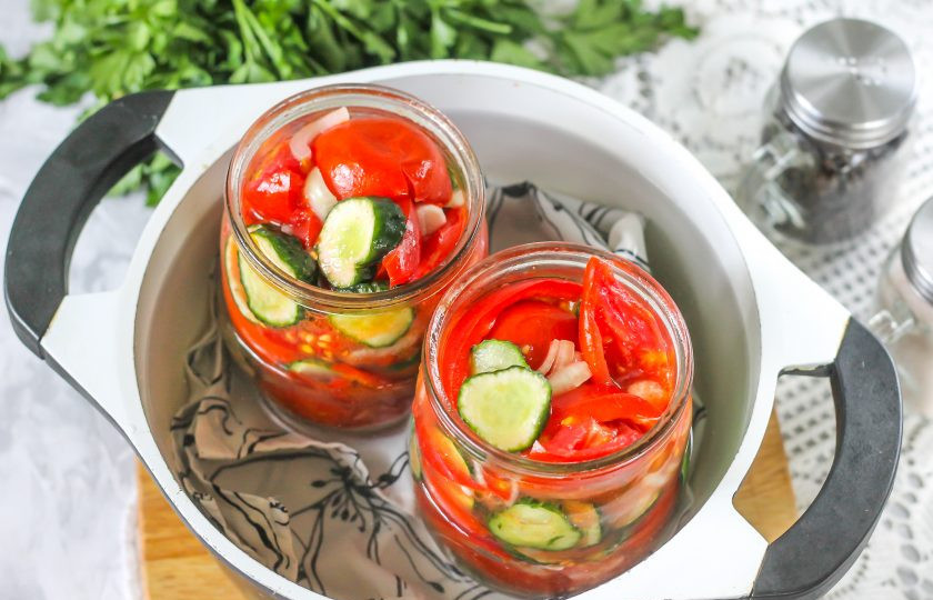 1. Этап. Салат из перцев, огурцов и помидоров на зиму: Застелите дно казана или кастрюли полотенцем, поместите в казан банки и залейте теплую воду в емкость, чтобы она доставала примерно до плечиков банок. Поместите емкость на плиту.