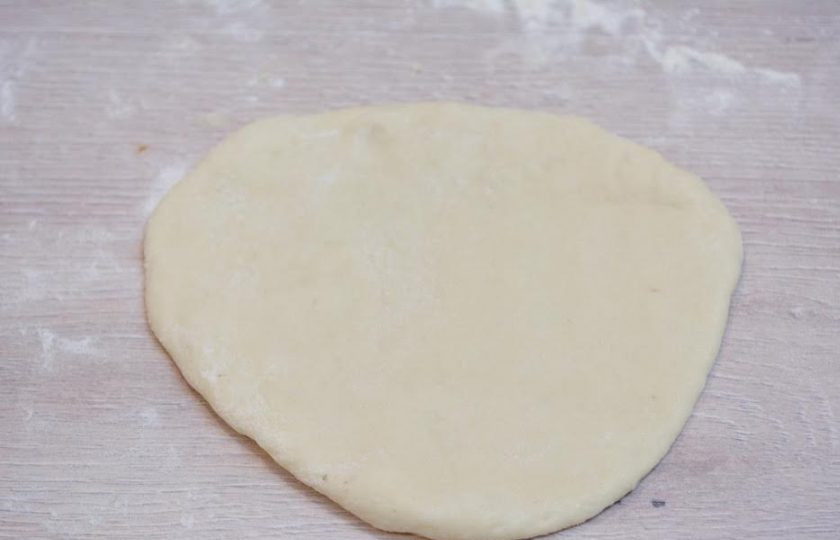 1. Этап. Ватрушки с творогом: 3. Раскатайте шарик теста на столе, присыпанном мукой.