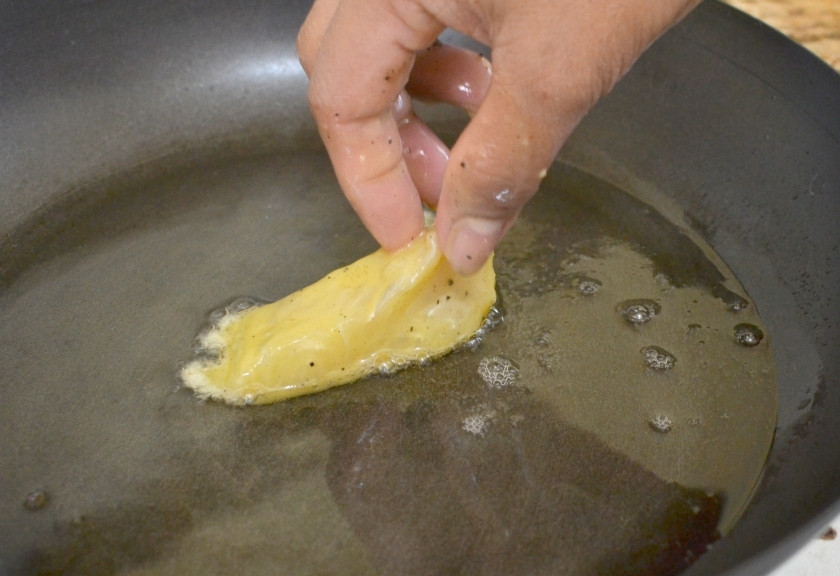 1. Этап. Рыба и чипсы: Жарьте рыбу в яйце на разогретом растительном масле, обжаривая с обеих сторон.