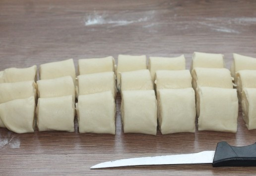 1. Этап. Пирожки из слоеного теста на кефире: 15. Разрезаем каждый рулет на 8 частей. Получилось 24 заготовки.