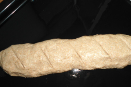 1. Этап. Хлеб из цельнозерновой муки без дрожжей: Прогреваем духовку. На противень, смазанный растительным маслом, выкладываем тесто. Формируем из него хлеб или батон. Ножом делаем несколько надрезов. Выпекаем хлеб в духовке 25 минут, температура 220 градусов.