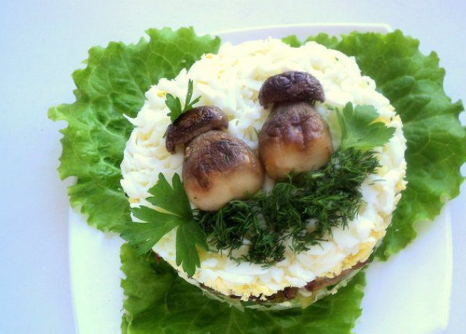 1. Этап. Салат Боровик: 9. Поверх желтка выложите белки, украсьте половинками грибочка, зеленью. Настаивайте салат в холодильнике от 30 минут.